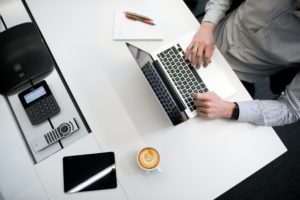 A desk and laptop being used to file a business interruption insurance claim.