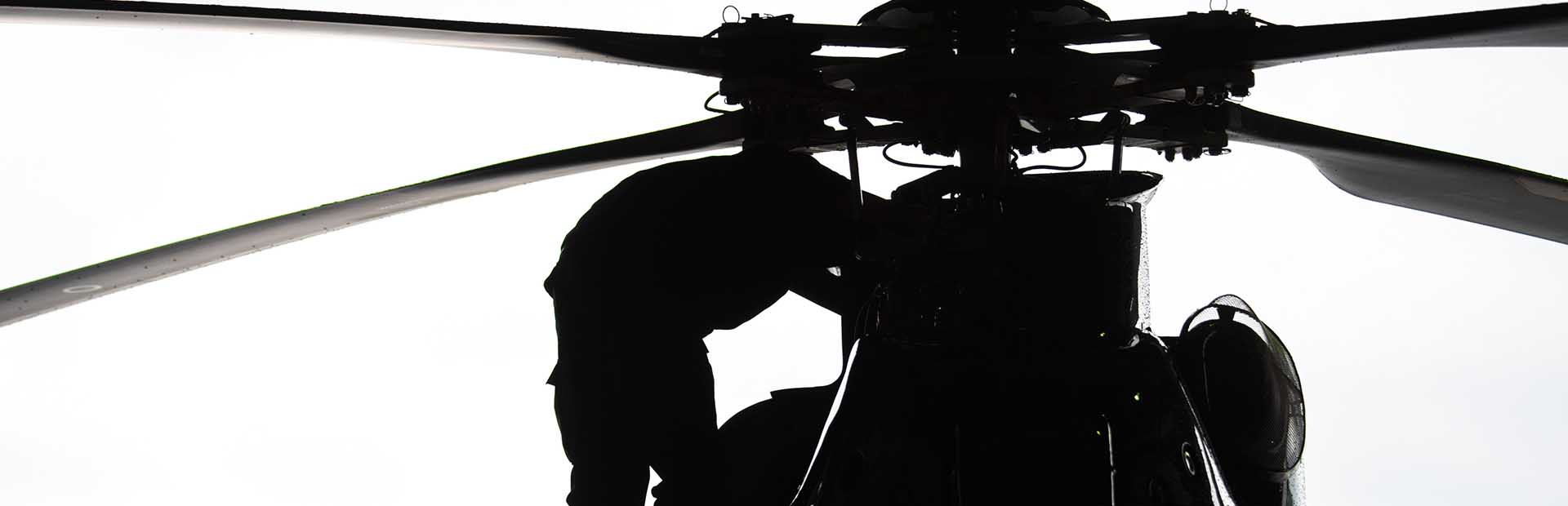 Person works on helicopter blades