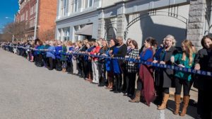 Beasley Allen staff members standing along the street holding commemorative ribbon