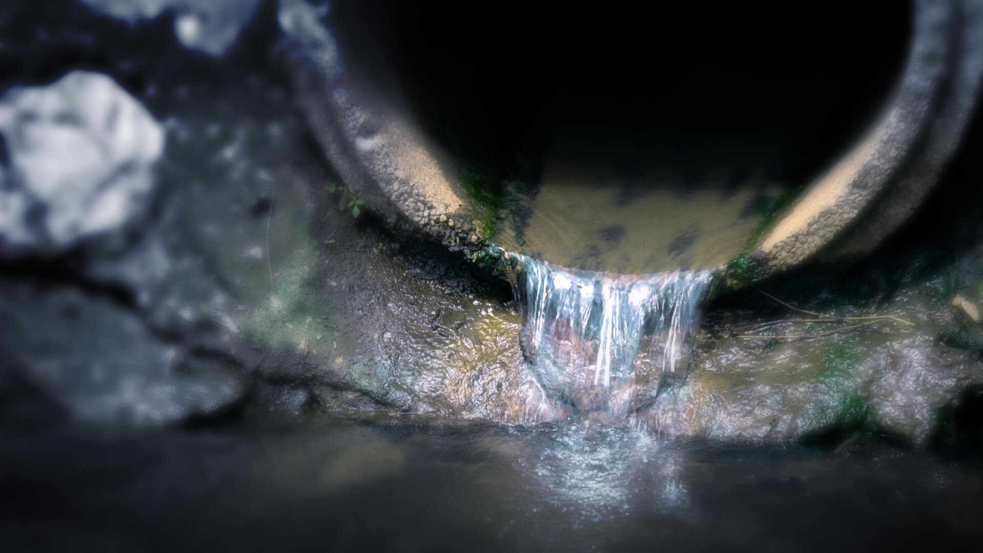 Contaminated water flows from a pipe into a body of water