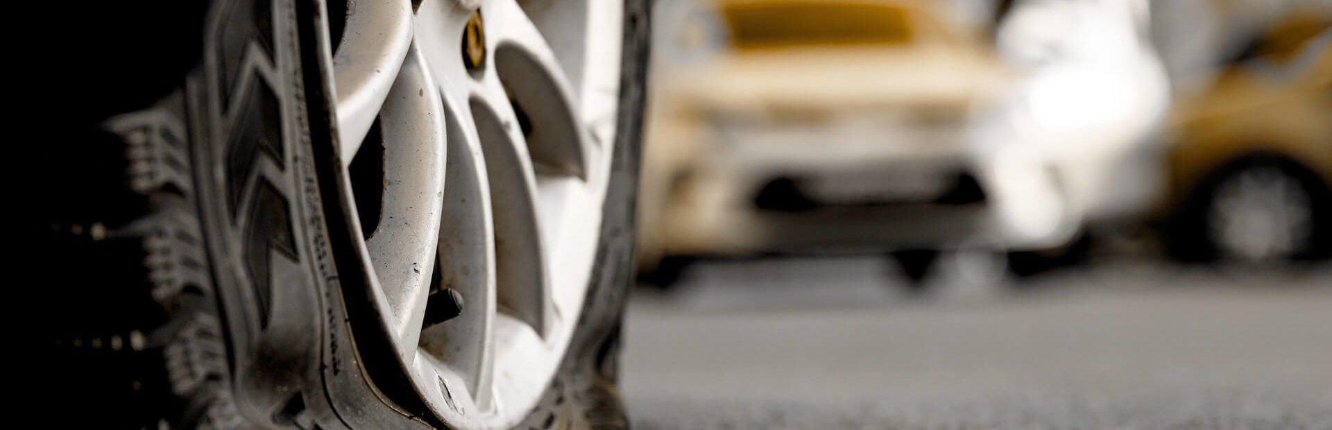 Defective Tires: Close up of a flat tire in traffic