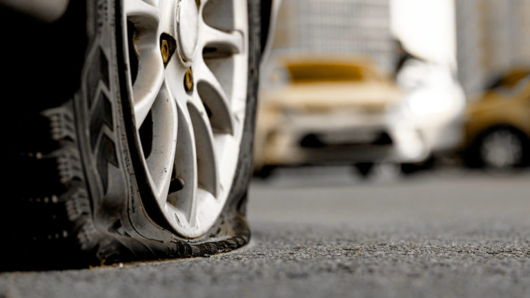 Defective Tires: Close up of a flat tire in traffic