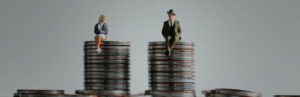 Equal Pay illustrated by male and female figures on stacks of coins
