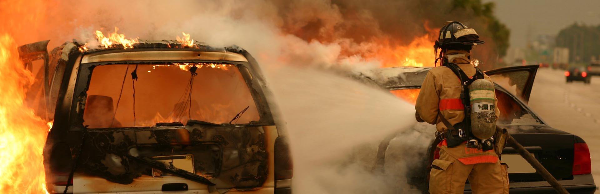 Firefighter works to extinguish fire engulfing Jeep vehicle in flames