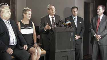 Melton family with Jere Beasley and Lance Cooper speaking at a Press event