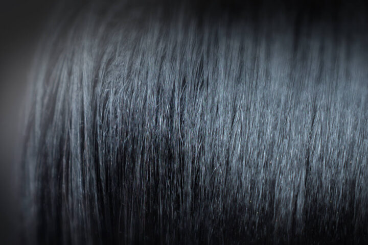 Close up of Black hair that has been treated with a chemical hair relaxer