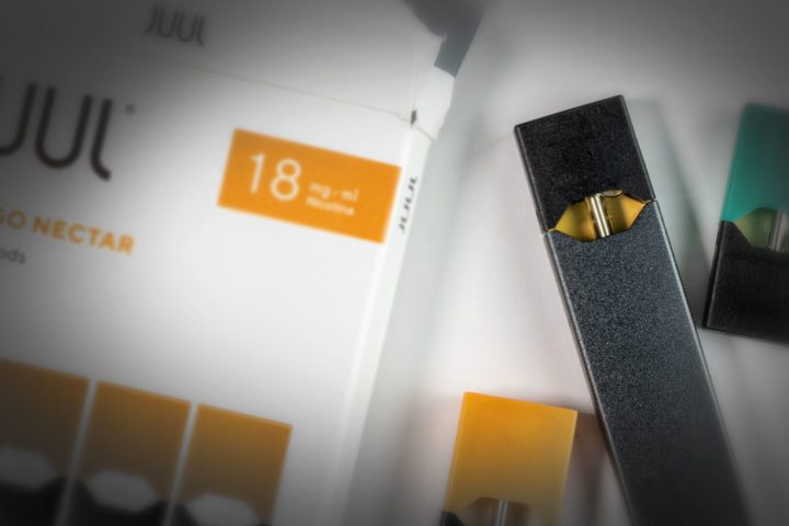 JUUL Vaping Device on a box of "Mango Nectar" flavored Cartridges