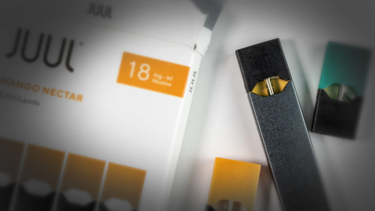 JUUL Vaping Device on a box of "Mango Nectar" flavored Cartridges
