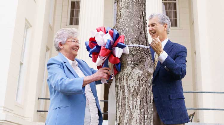 Gov. Kay Ivey and Pastor Jay Wolf place a ribbon to kick off the Ribbons of Hope campaign, which encourages prayer for those working to stem the coronavirus pandemic.