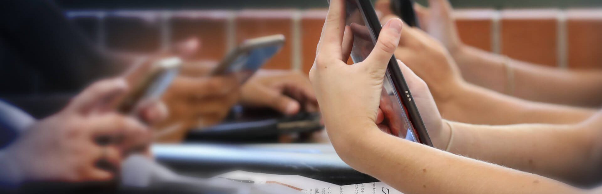 Young people looking at their phones in a school setting