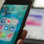 A phone displaying social media apps on phone home screen with a notification from Facebook, Instagram and Twitter