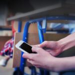 Student checks their phone secretly under a desk in a classroom